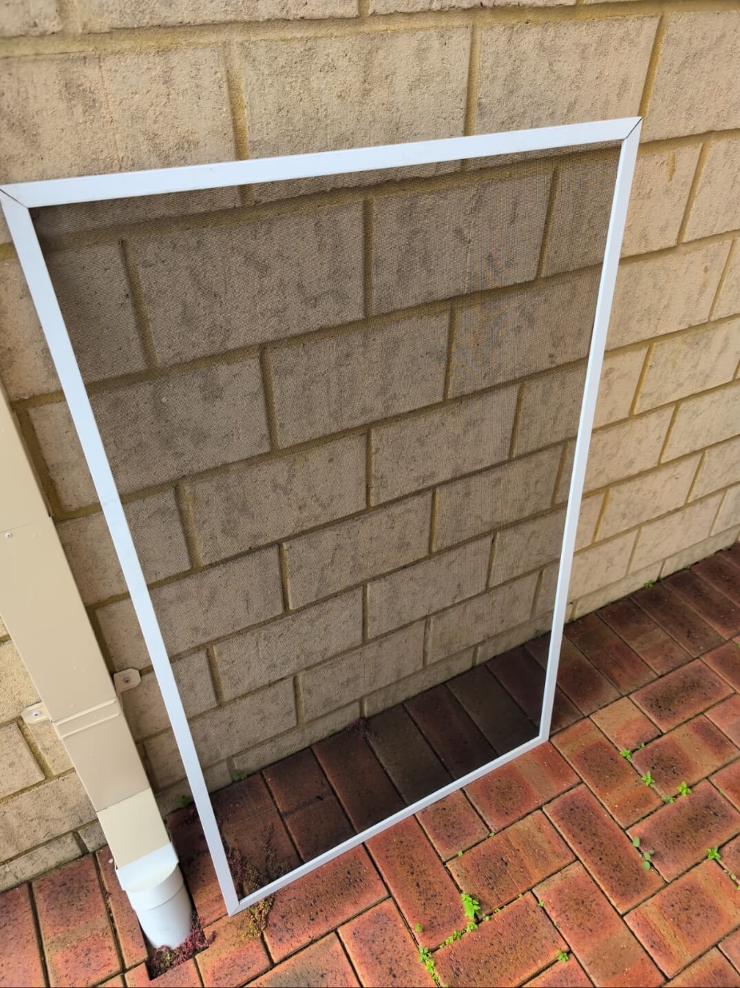 A professional re-meshing a fly screen frame on-site.